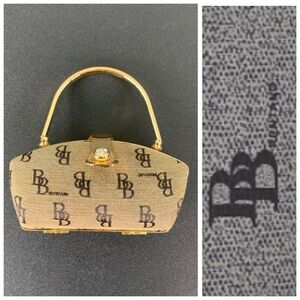 B. Brentano tan and black hard side mini purse.